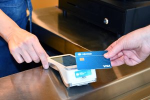 Cliente pagando con tarjeta en TPV Cajamar en un comercio físico.