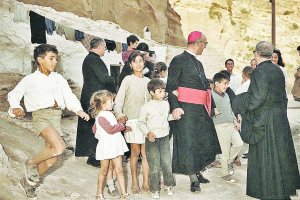 El obispo Suquía el día que subió a las cuevas de los cerros de la Chanca y le dio la mano a los niños y llevó la esperanza a los enfermos. Detrás de él estaba la figura del cura don Marino.