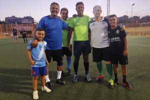 Paquito en el centro de amarillo rodeado de su hijo, nietos y amigos.