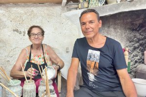 Loli García pintando en su taller de alfarería de Níjar, enseñando sus trabajos al periodista Antonio Hermosa.