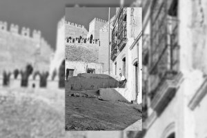 Puerta de la casa donde vivía la señora Patro con su hermano ‘el Sierra’, que aparece sentado en una silla tomando el sol.