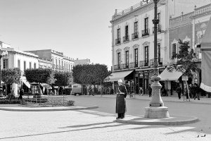 La Puerta de Purchena en 1950, con el guardia que regulaba el poco tráfico que había y con las boñigas que dejaban los coches de caballos.