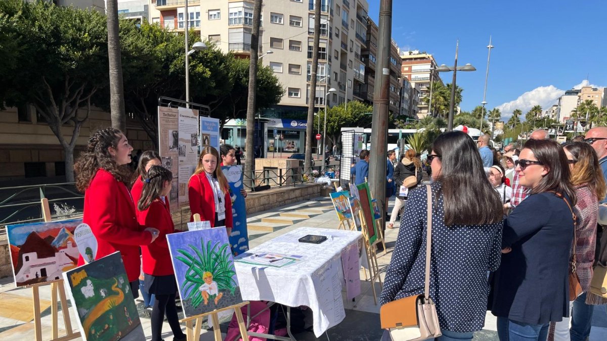 Unas alumnas enseñan a los curiosos que paseaban por la Rambla sobre el movimiento Indaliano.