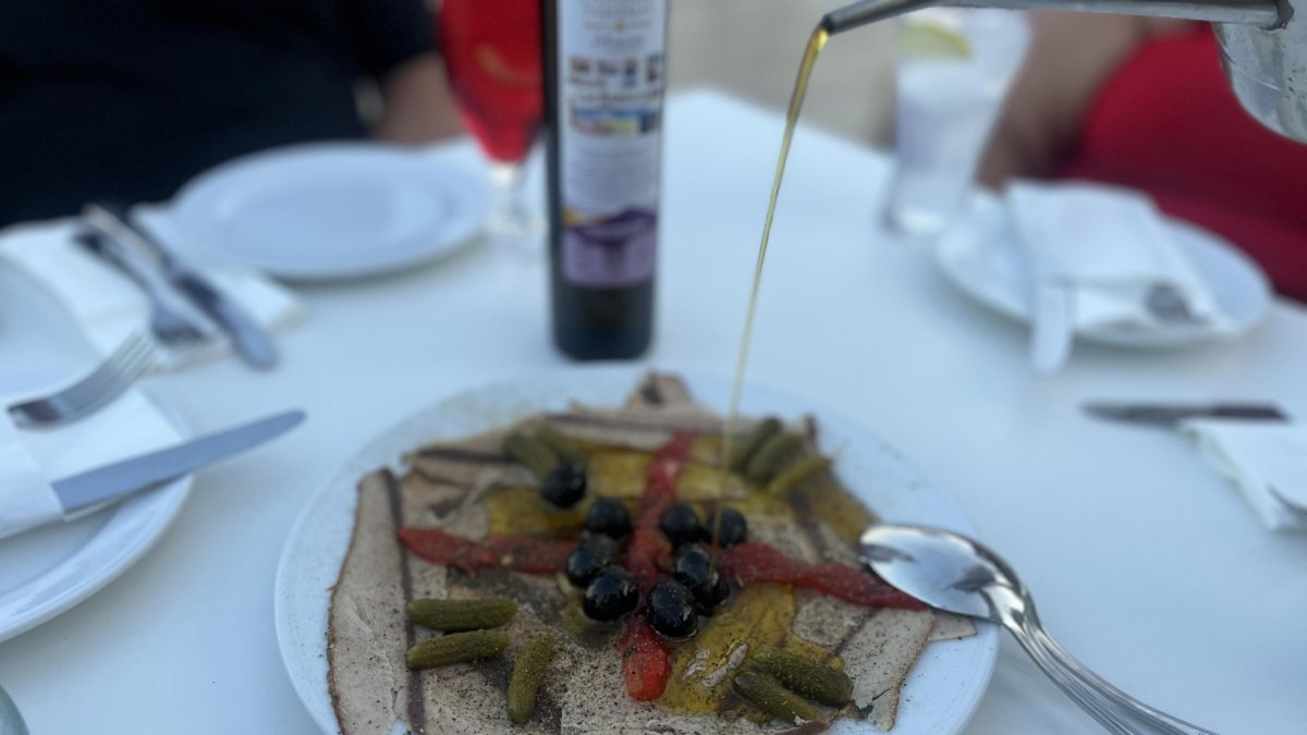 Plato de bonito ahumado servido en 'Los Barquicos' con un hilo de aceite de la zona