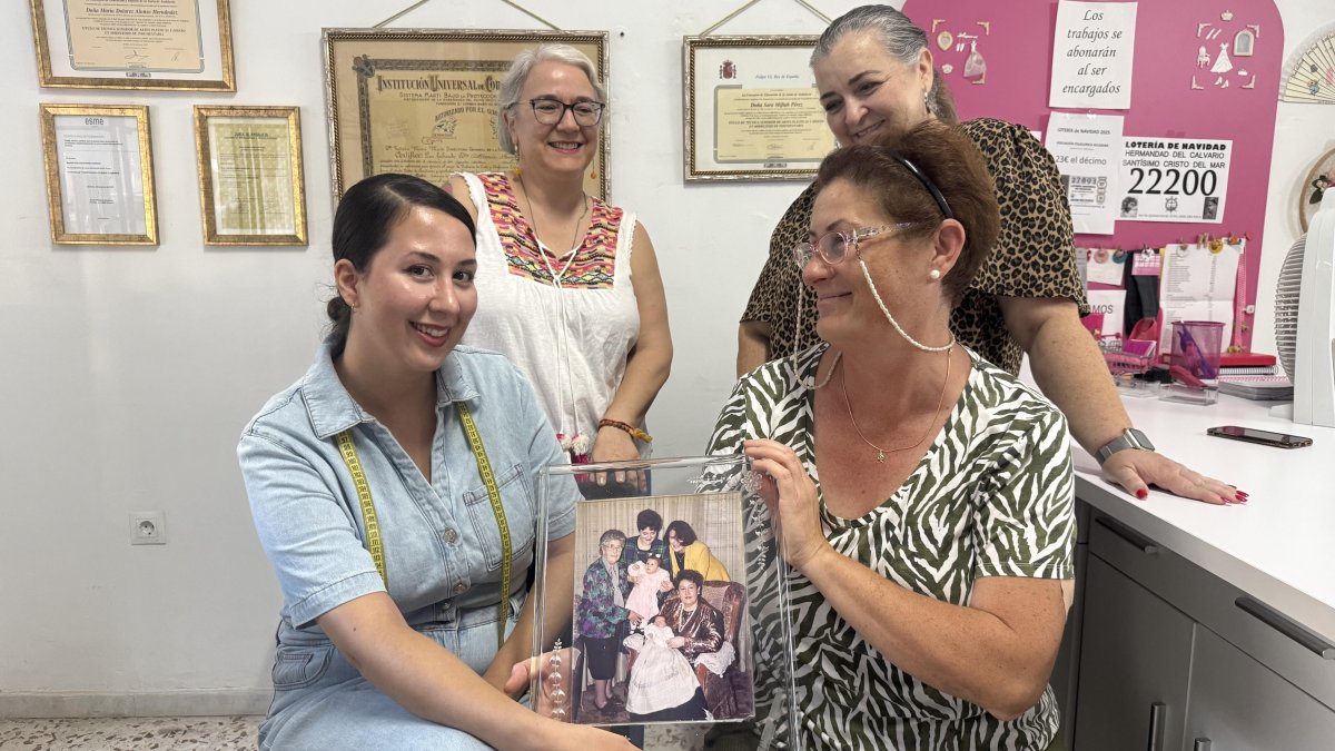 Lola Pomedio, Mariola Pérez, Sara Pérez y Mercedes Pérez, sosteniendo el cuadro de su familia que siempre tienen en el taller.
