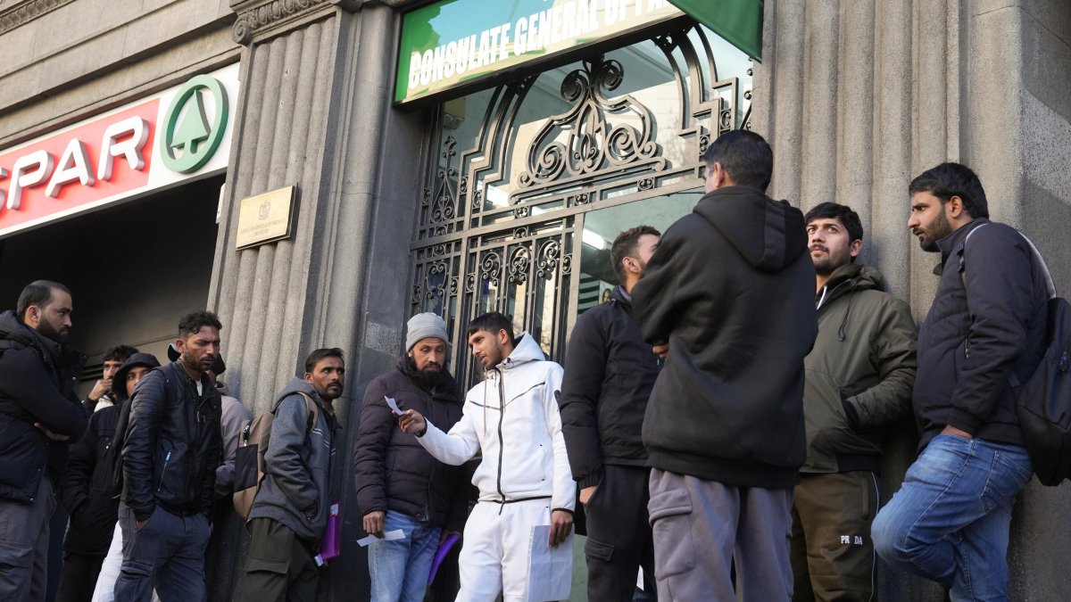 Colas de inmigrantes ante un consulado en España.