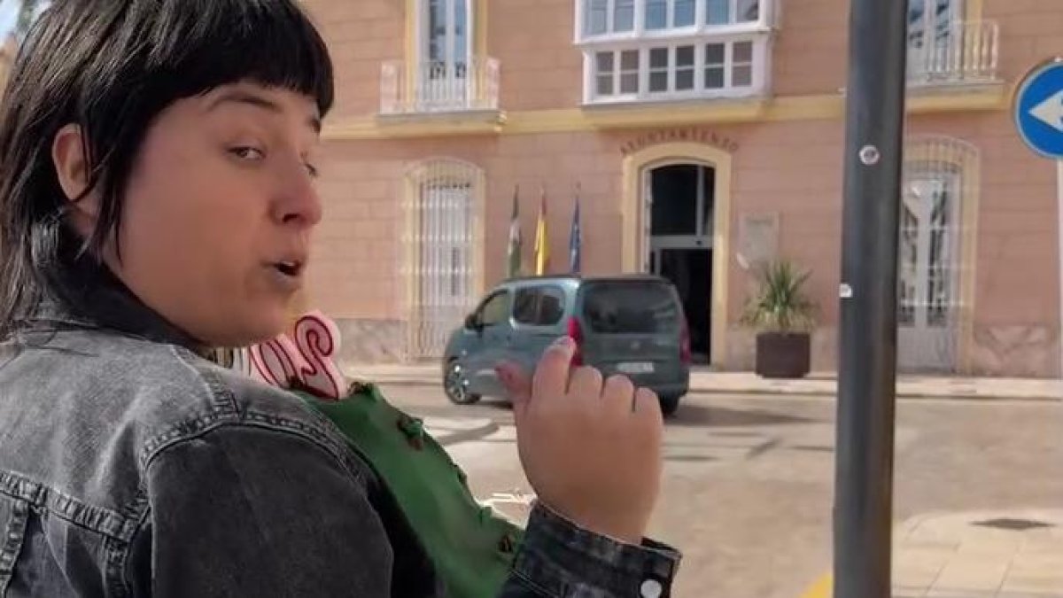 Una de las miembros de Greenpeace con la tarta en las manos frente al ayuntamiento.