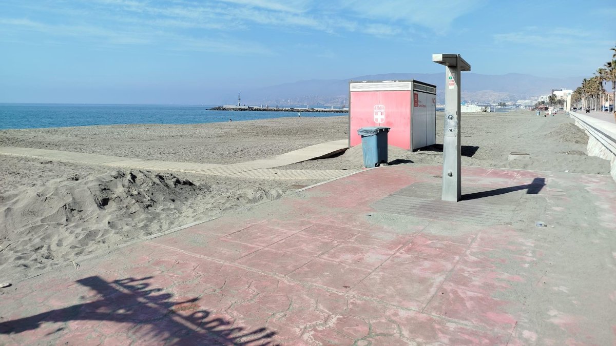 Junto a la plataforma de las duchas y el murete del paseo marítimo se amontona la arena que ha quedado ahí tras el paso de los temporales