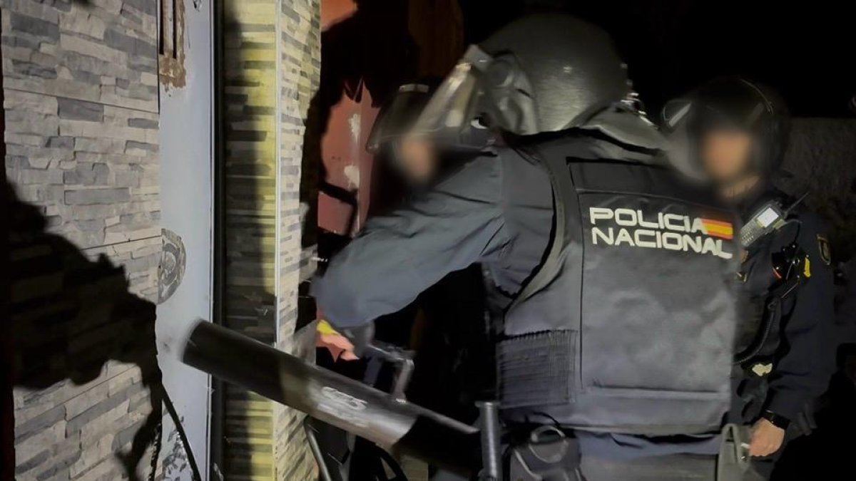 Agente de la Policía nacional golpea con un ariete la puerta de una vivienda para entrar al asalto.