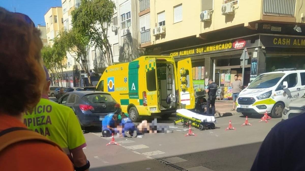 Los pasajeros de la moto, tendidos en el suelo tras el accidente.