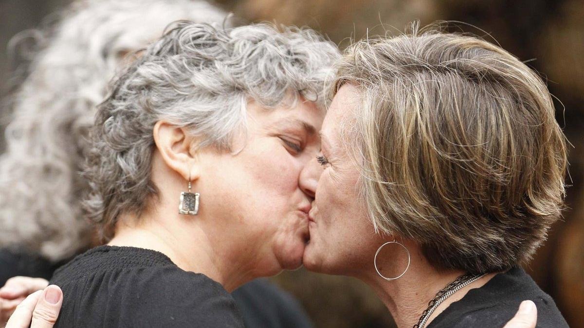 Dos mujeres se besan.