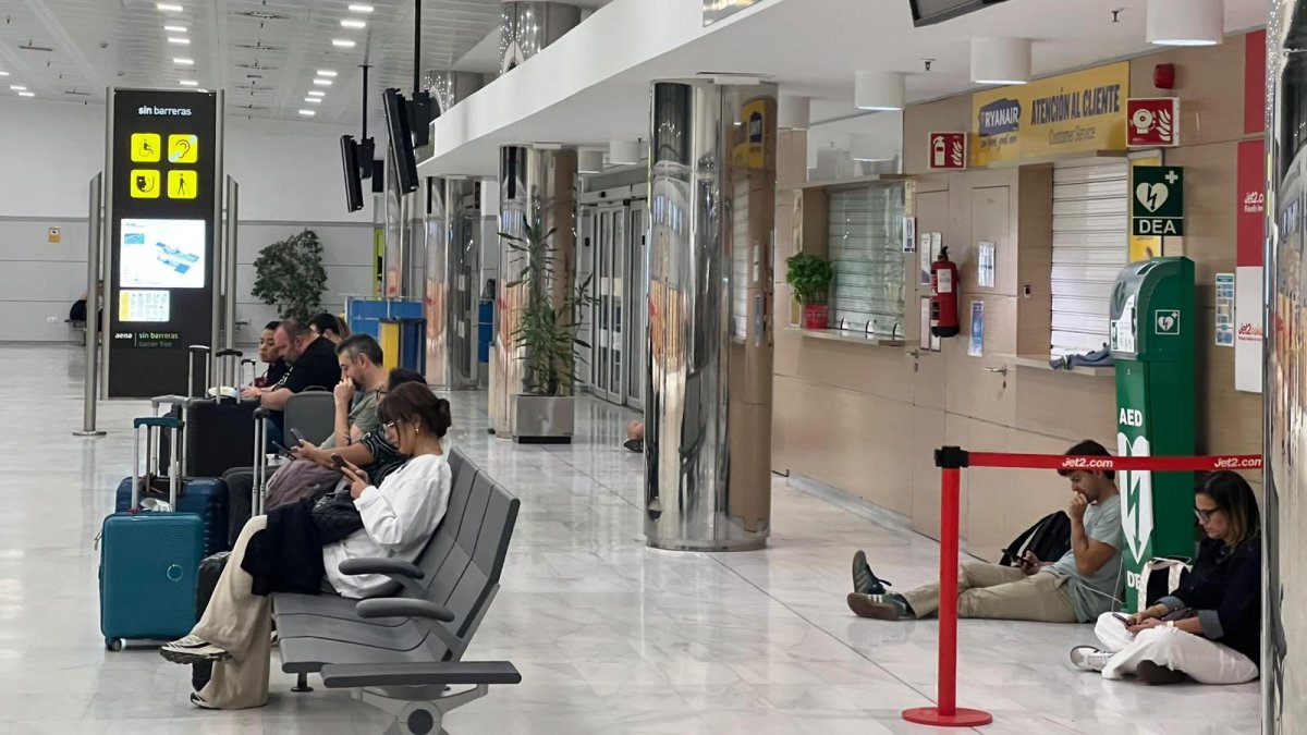 Pasajeros esperan noticias del vuelo de Almería a Madrid, que finalmente ha sido cancelado por el temporal.