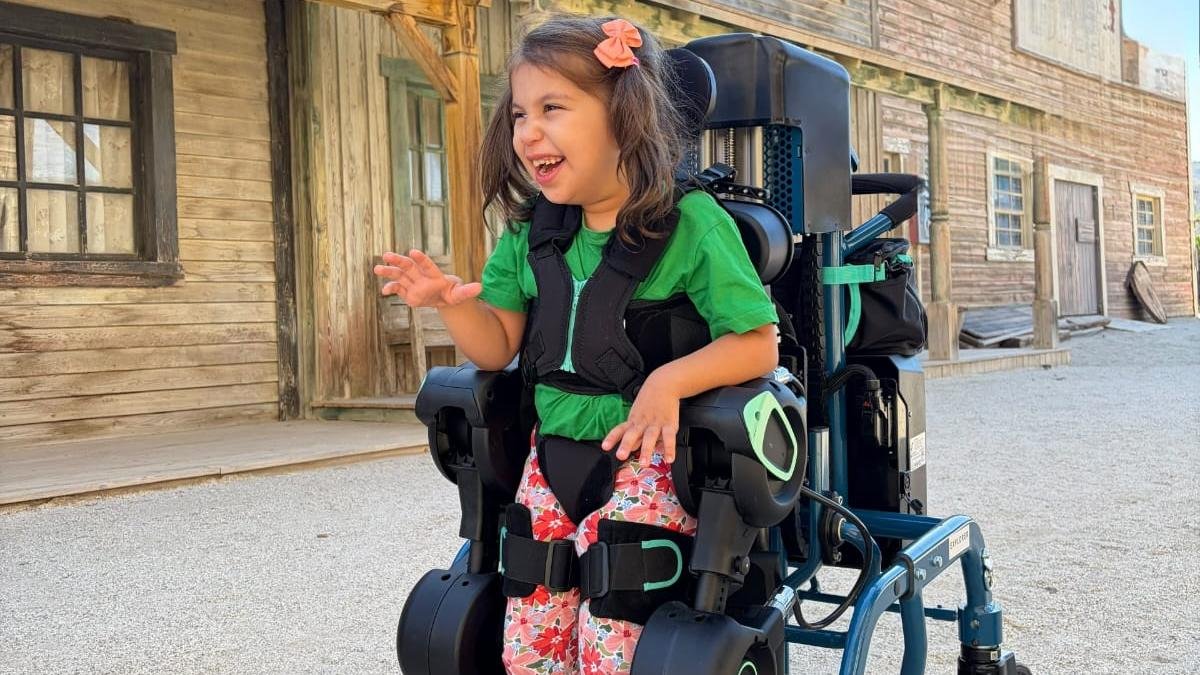 Nora, de seis años y medio y con parálisis cerebral, prueba el exoesqueleto EXPLORER MB durante la jornada celebrada en MiniHollywood Oasys de Almería