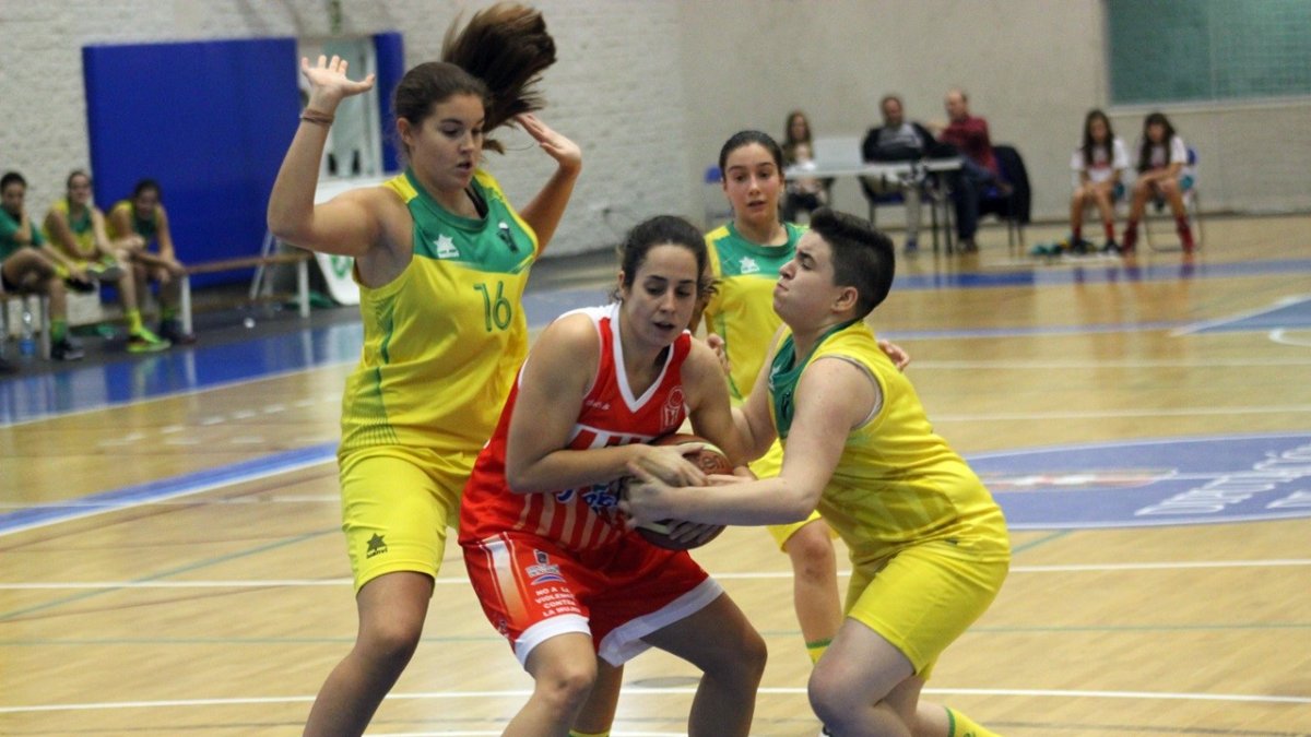 La jugadora rojilla rodeada de contrarias.