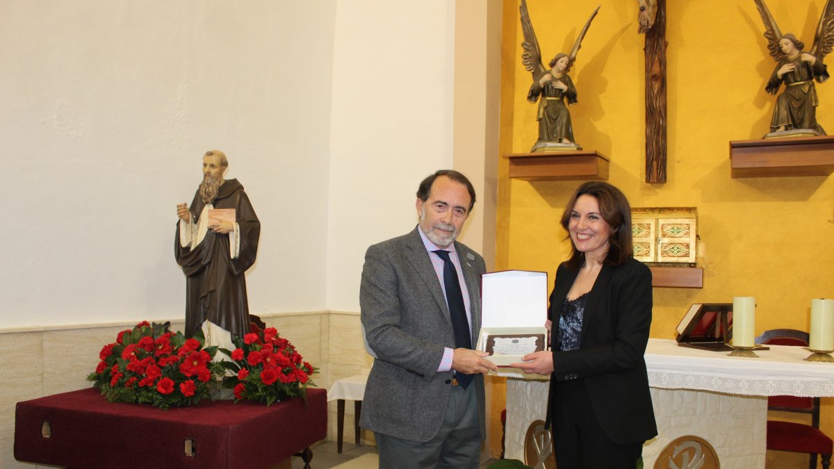 El pregonero, Juan José Melero recibe una placa de manos de la presidenta, Magdalena Cantero.
