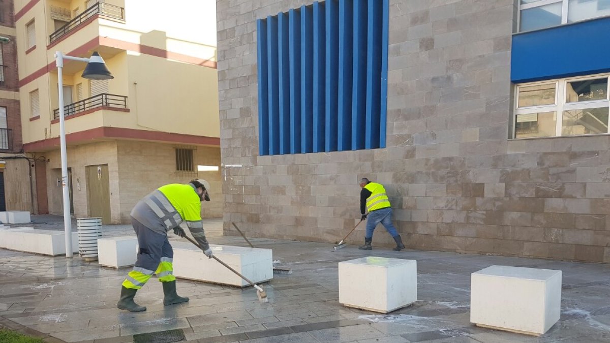 Operarios realizan labores de baldeo y limpieza de calle en el centro de Adra.
