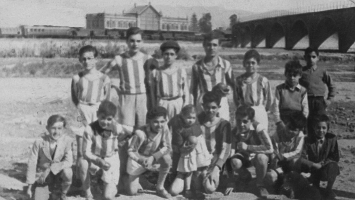 Jóvenes de los años cincuenta en el campo de fútbol a la espaldas de la estación. Se puede ver el puente que llevaba el tren hasta el embarcadero de