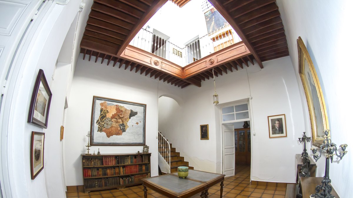 El vestíbulo de la vivienda recibe al visitante con la luminosidad que proyectan los lucernarios del patio central. Al fondo, un mapa del siglo XIX c