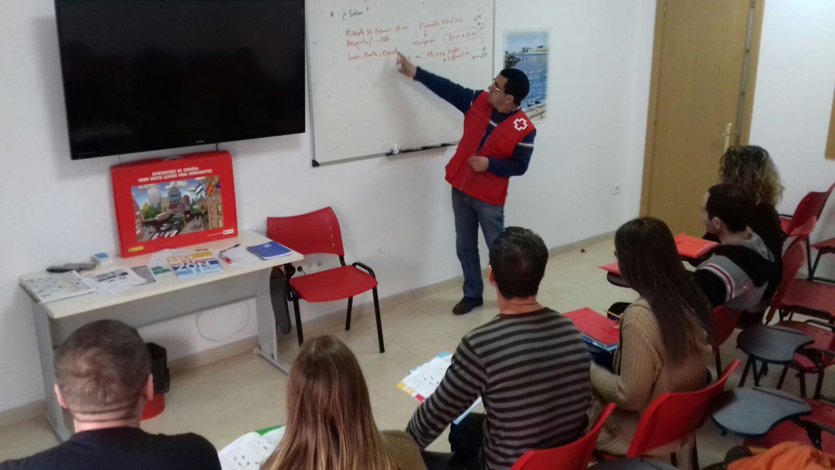 Un técnico de Cruz Roja explica a varios de los refugiados acogidos en el centro de Roquetas .