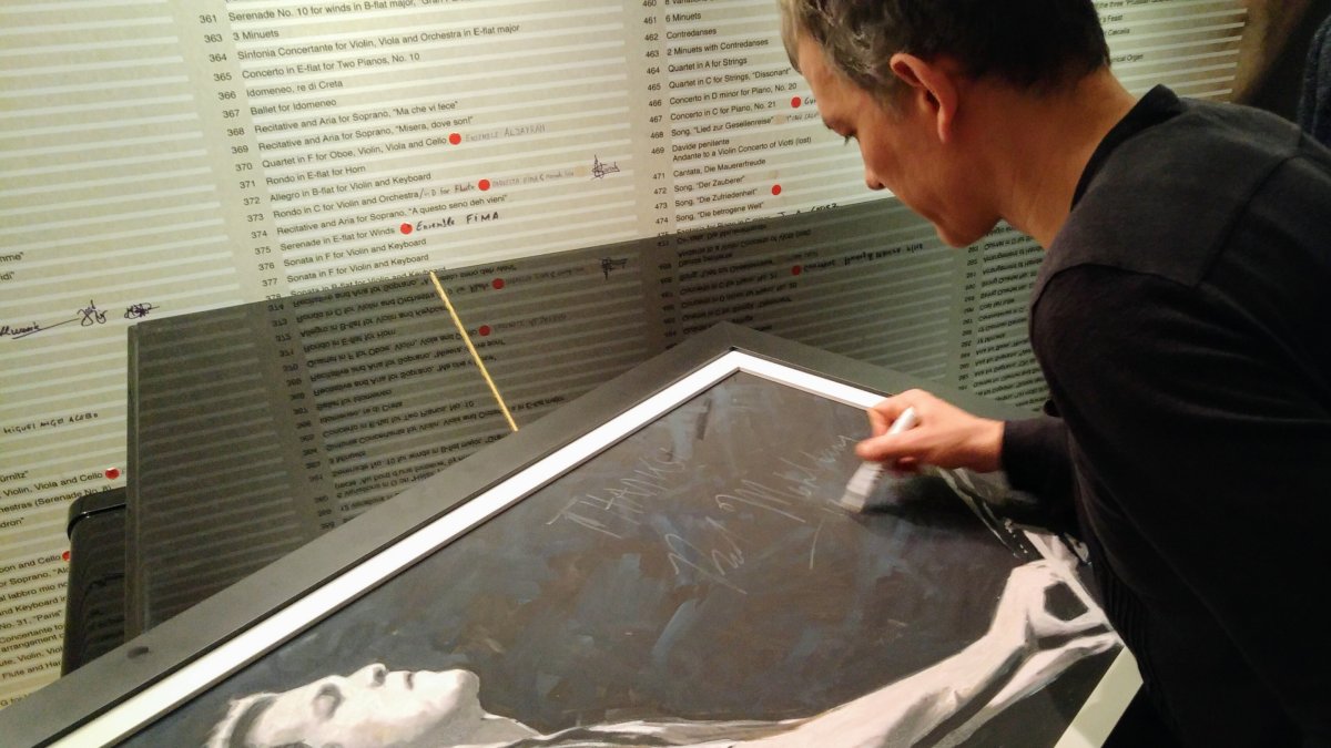 Brad Mehldau firmando en la sede de Clasijazz, tras el concierto, un retrato realizado por Epifanio Serna. (Foto: Juanjo Simón)