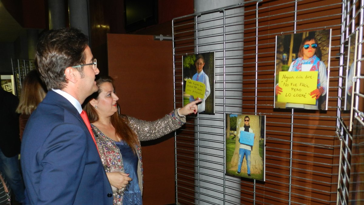 Eva Martínez mostrando las fotografías de miembros de Down El Ejido a Francisco Góngora.