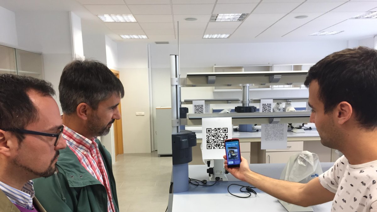 En la imagen,  uno de  participantes con la aplicación de códigos QR acompañado por los investigadores.