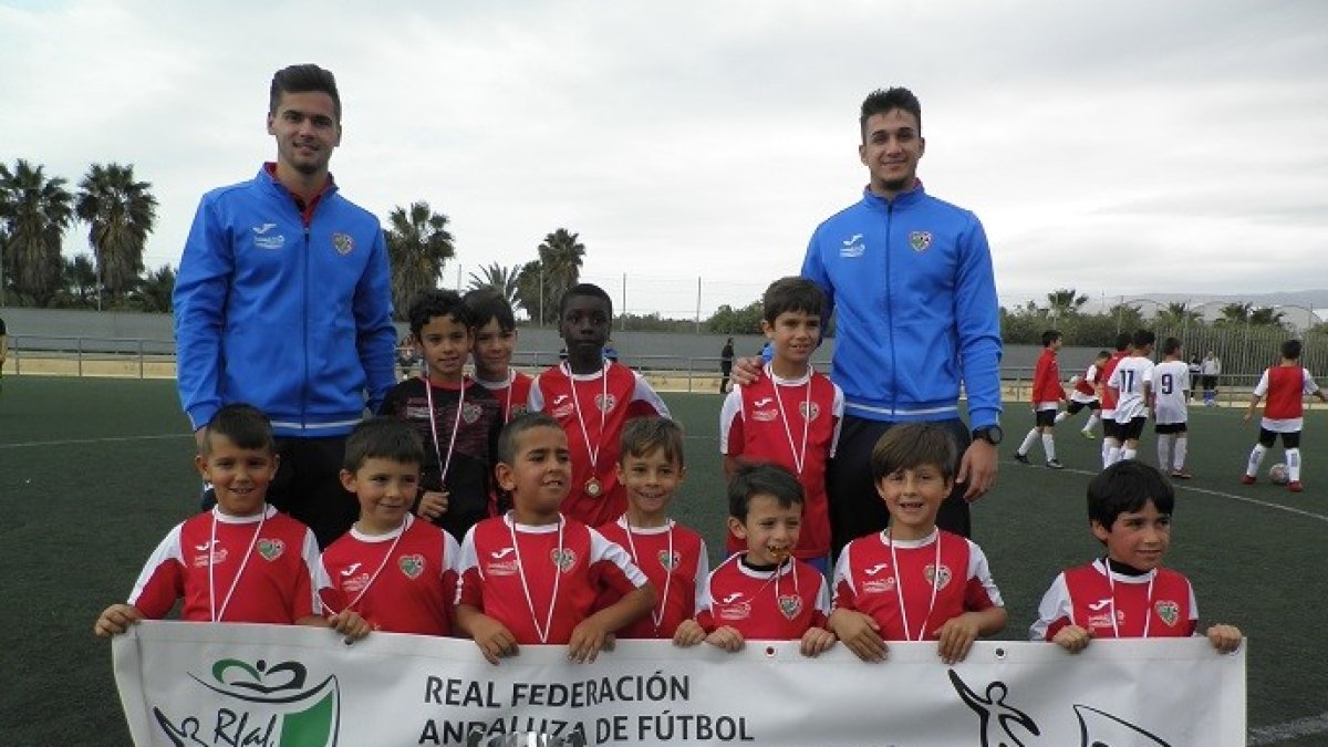 Los campeones posan con la pancarta de la FAF.