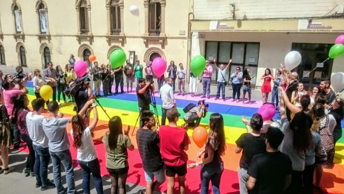Bandera arcoíris desplegada en la Plaza de la Escuela de Artes.