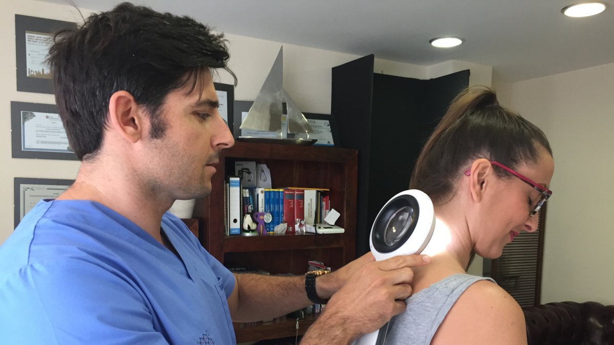 José Luis Martínez Amo revisa los lunares de una paciente en su consulta.