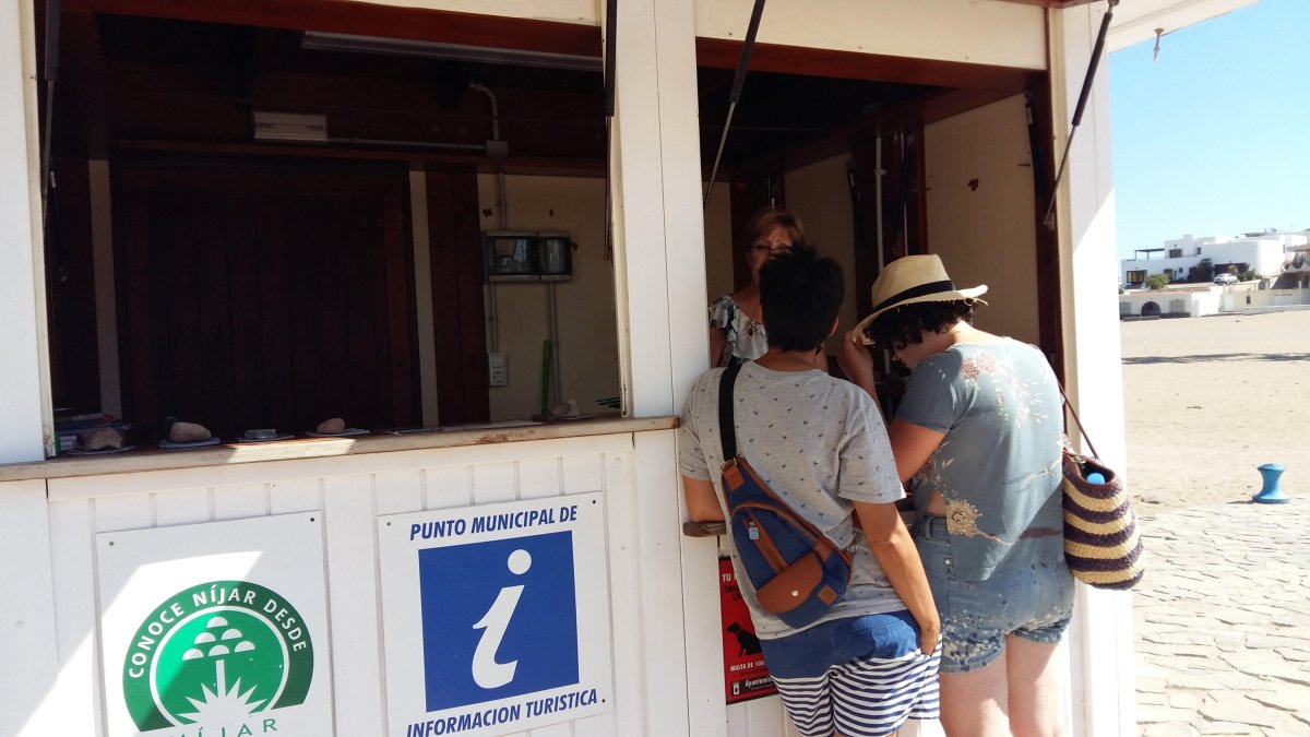 Turistas informándose en uno de los puntos municipales.