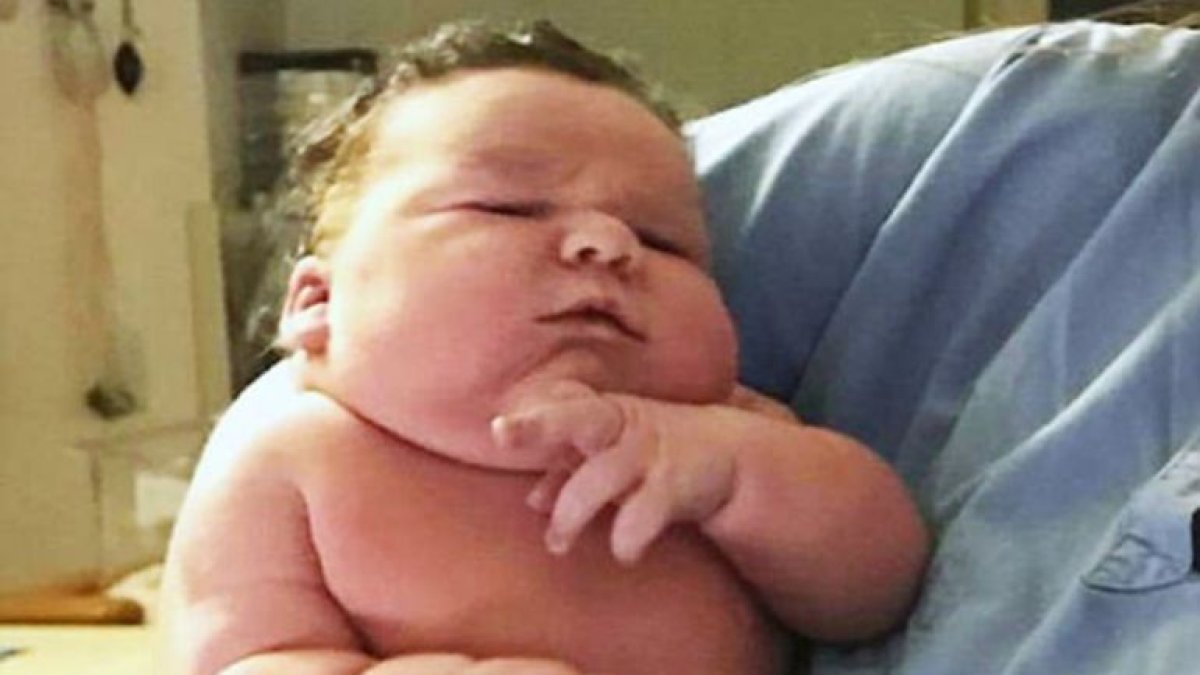 El padre posa junto a su hijo recién nacido.