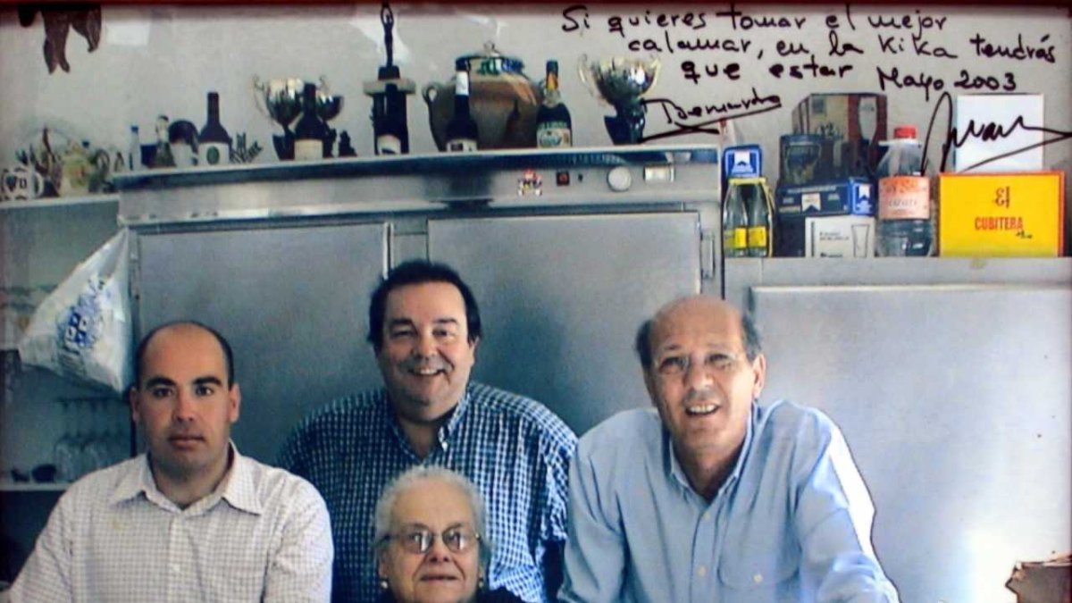 Araceli Nieto, de luto, en la barra de su célebre restaurante La Kika en El Alquián, junto a su hijo Gabriel a su derecha, y unos asiduos clientes,