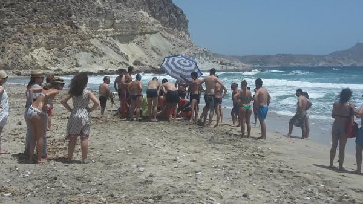 Bañistas atendiendo a una persona ahogada en la Cala del Plomo en el verano de 2015.
