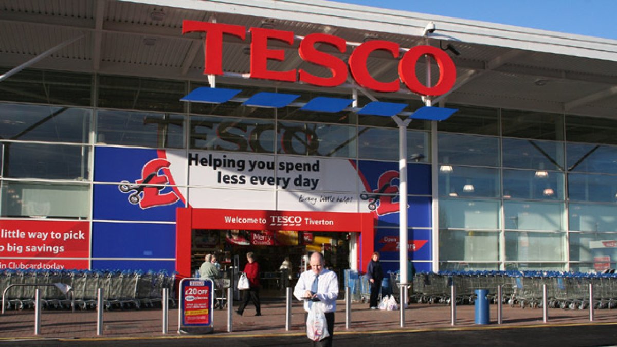 Un cliente sale de un supermercado Tesco.