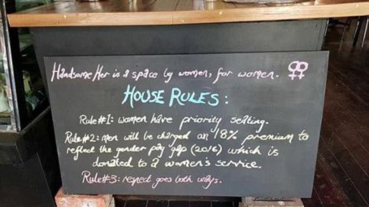 Imagen del cartel que explica las condiciones por las que el hombre debe pagar un 18% más por un café.