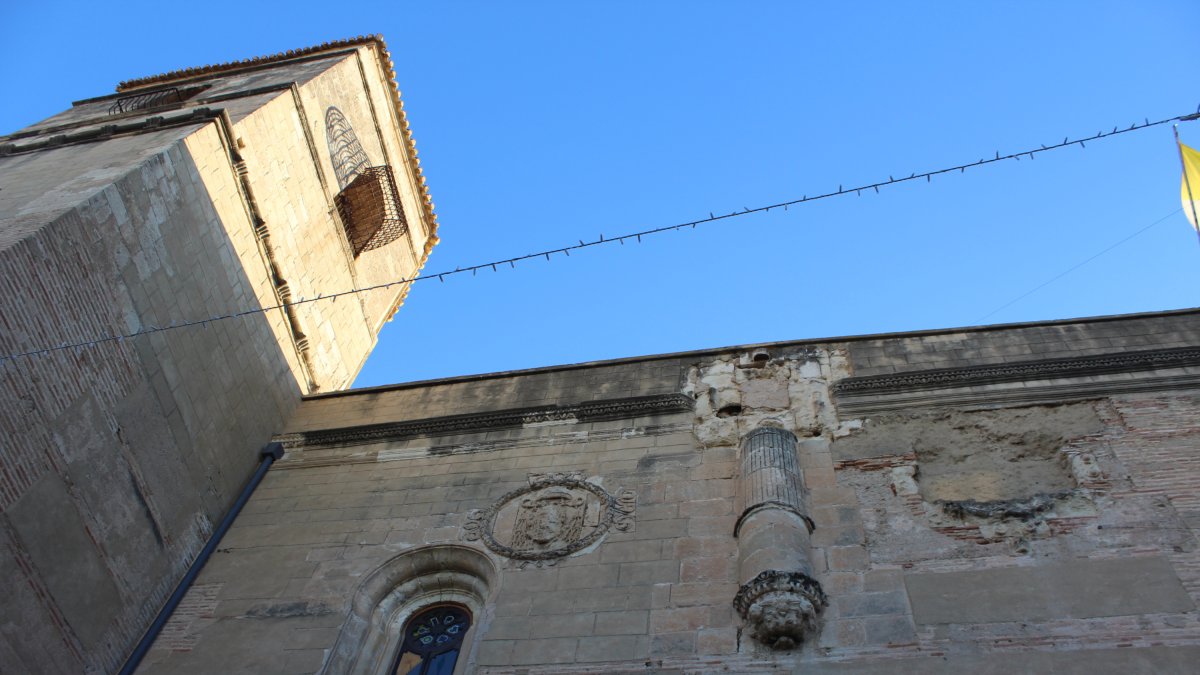Fachada de la iglesia parroquial de Nuestra Señora de la Encarnación, con los restos de escudos originales.