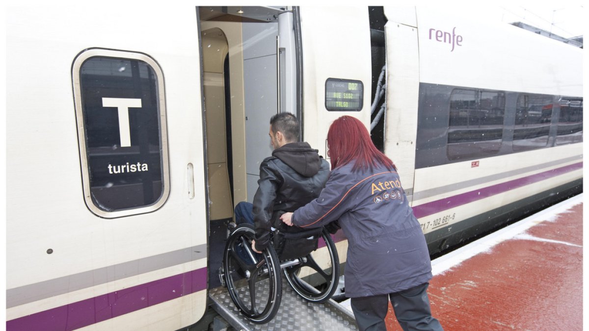 Personal de Atendo ayudando a un pasajero en silla de ruedas.