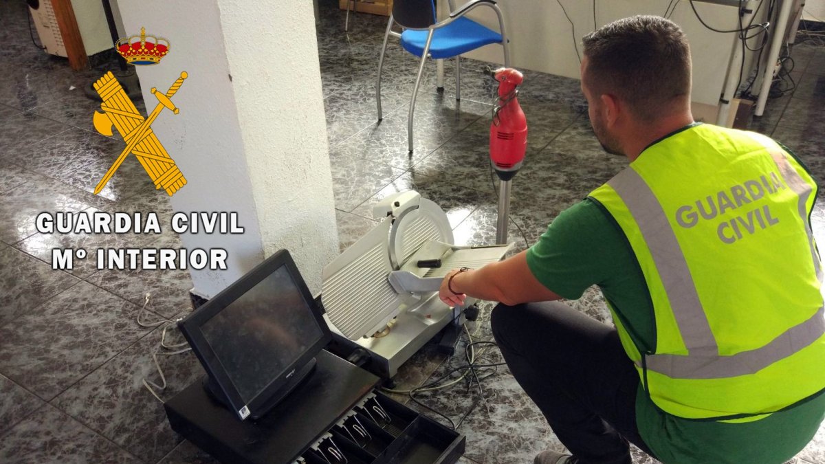 Agente de la Guardia Civil con algunos de los objetos robados.