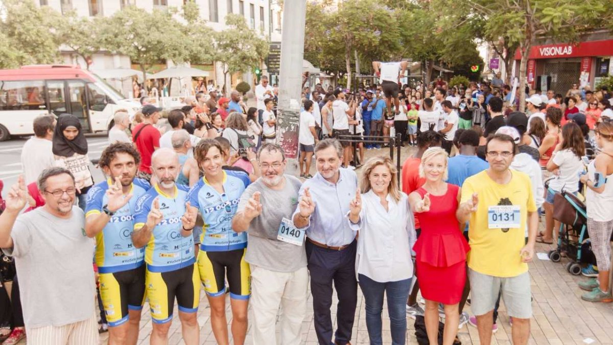 por los refugiados. Los tres ciclistas, junto con Pilar Ortega, Ángel Escobar y miembros de asociaciones.