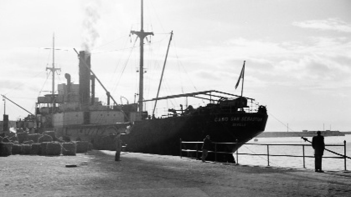 El vapor Cabo San Sebastián, atracado en el puerto de Almería en el invierno de 1955 mientras se embarcaba un cargamento de esparto hacia Barcelona.