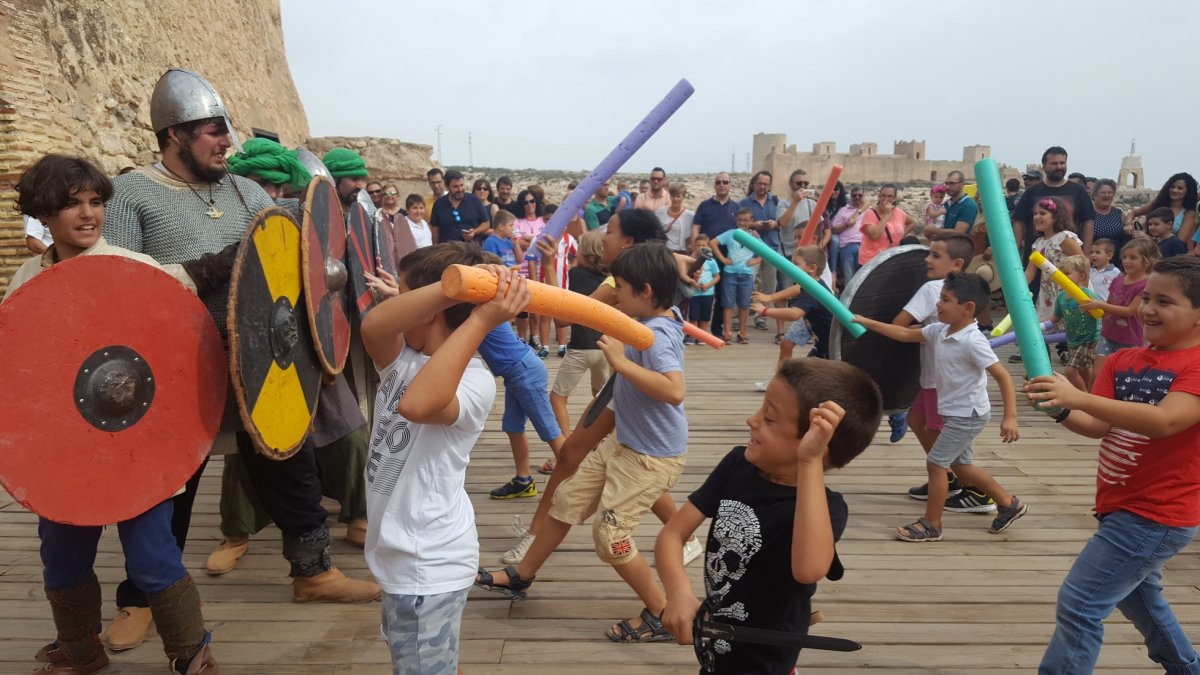 Niños cargan con sus espadas en un juego.