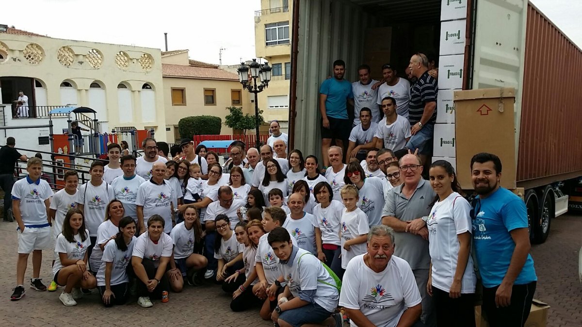 Miembros y voluntarios del Banco de Libros de Tíjola junto al camión con el material escolar.