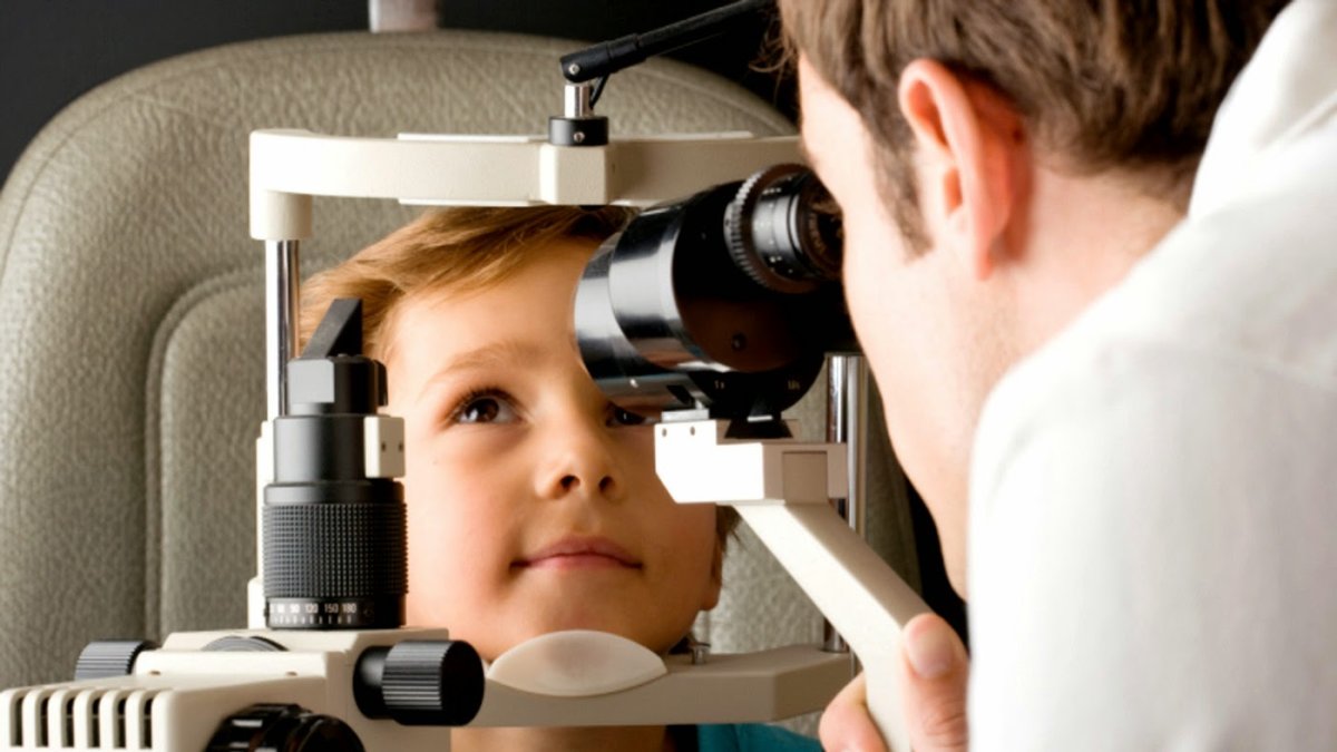 Un niño revisándose la vista en la consulta de un óptico-optometrista. L
