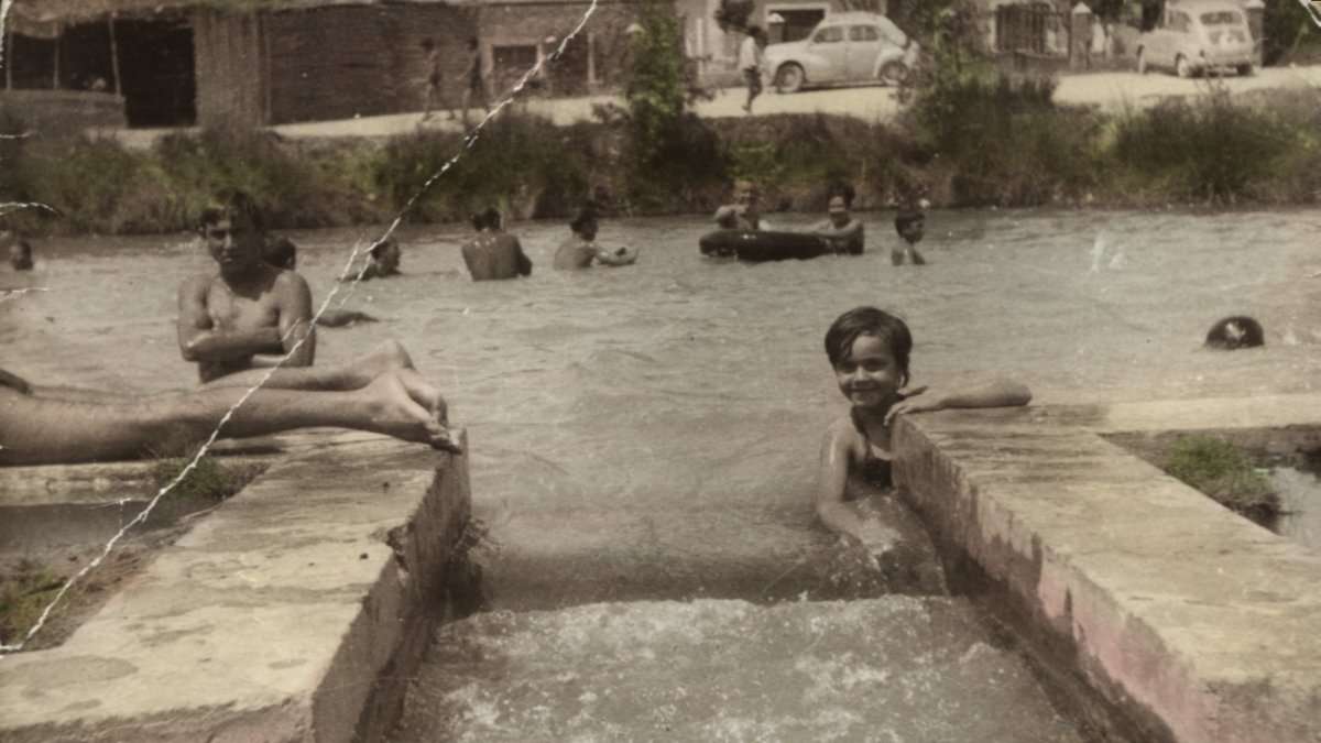 Una de las fotos de la exposición, en la que se puede ver bañistas  disfrutando en la balsa.