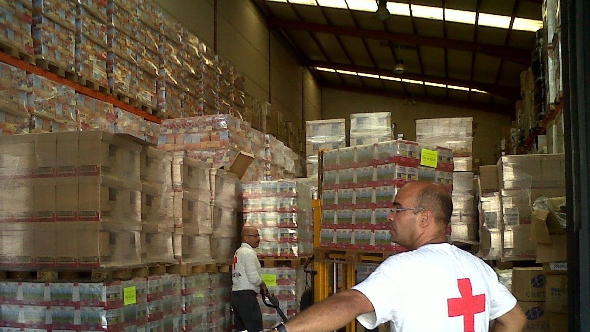 Imagen de archivo de ayudantes de Cruz Roja en un almacén de comida para repartir.
