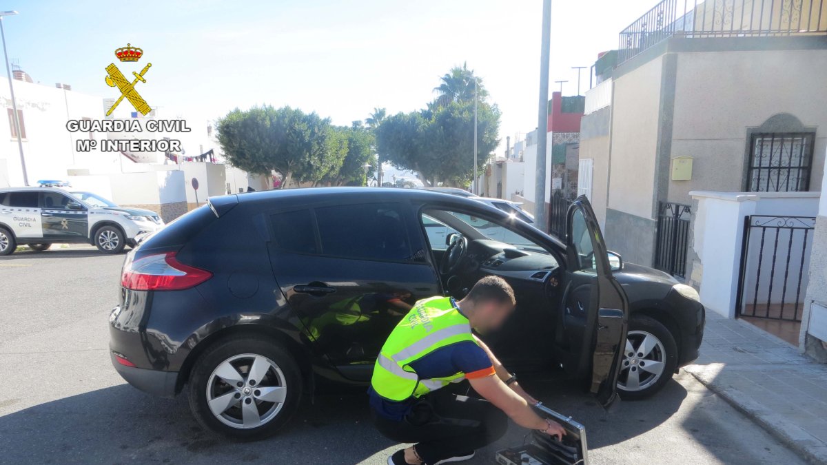 Un agente, junto a uno de los coches forzados.