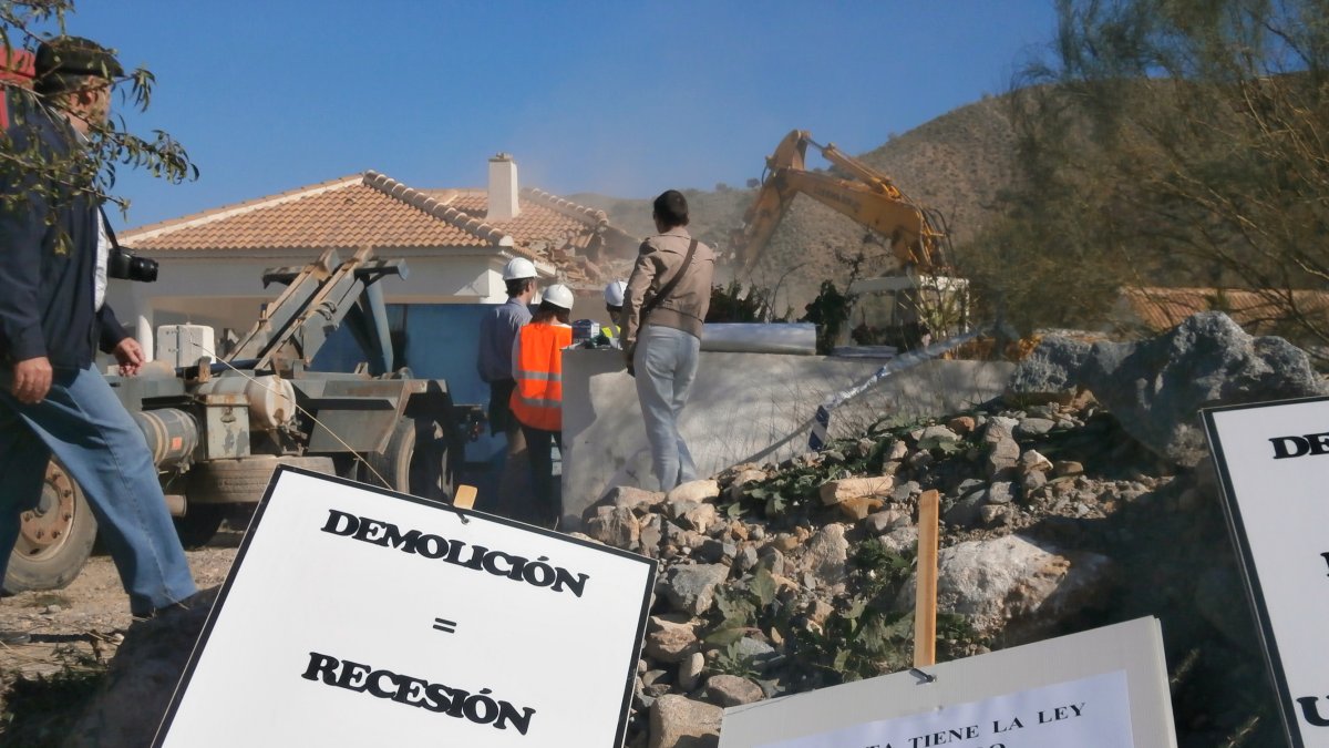 Pancartas de protesta tras una demolición de una vivienda ilegal años atrás.