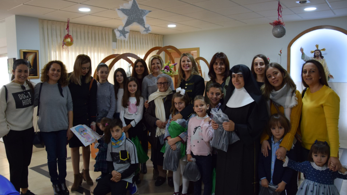 Foto de familia de los más pequeños con sus familiares y algunas de las religiosas.