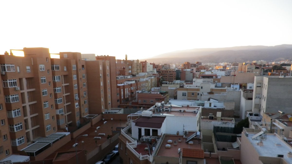 Bloques de pisos a la izquierda y casas de planta baja a la derecha. Al fondo, las montañas bajo las cuales se sitúa el casco histórico.