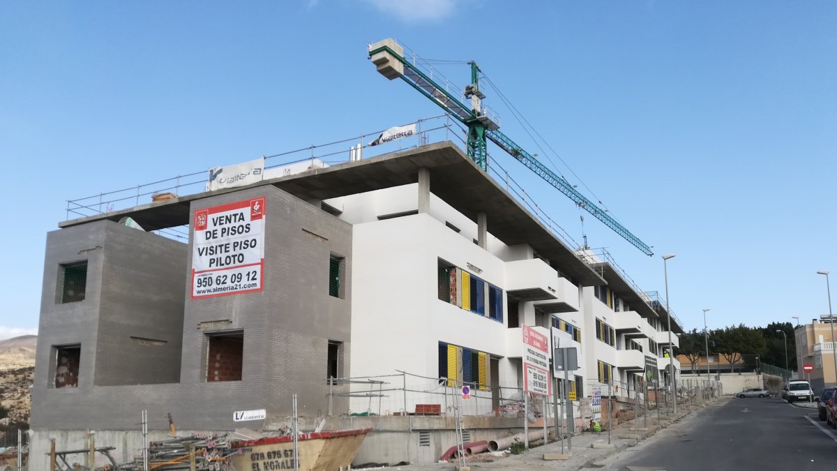 Obras de construcción del edificio en el que se puede ver el cartel para la visita al piso piloto.
